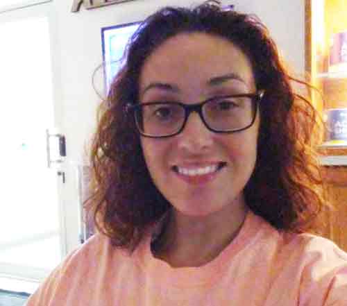 a woman in a pink shirt and glasses