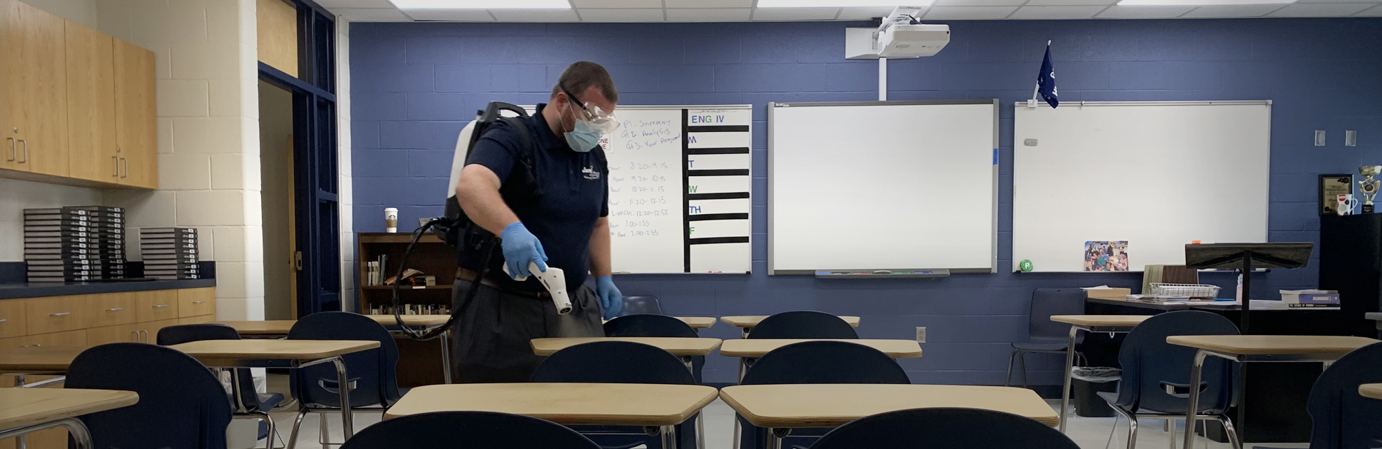 a man in a classroom setting up his desk