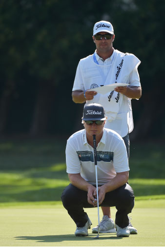 person lines up a putt on the 18th green during the final round of the players championship at